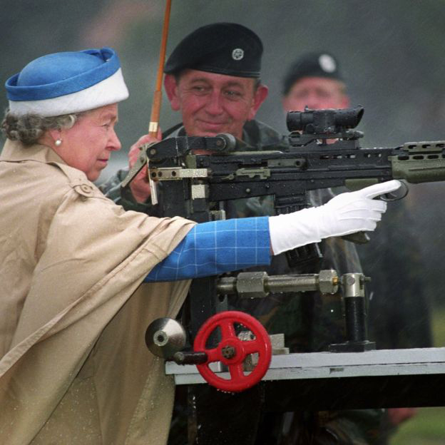 Queen Elizabeth II, with Chief Instructor, firing the last shot on a standard SA 80 rifle