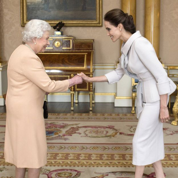 Actress Angelina Jolie (right) being presented with the Insignia of an Honorary Dame Commander of the Most Distinguished Order of St Michael and St George by Queen Elizabeth II