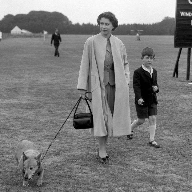 Queen Elizabeth II walking through Windsor Great Park with Prince Charles to watch the Duke of Edinburgh play polo